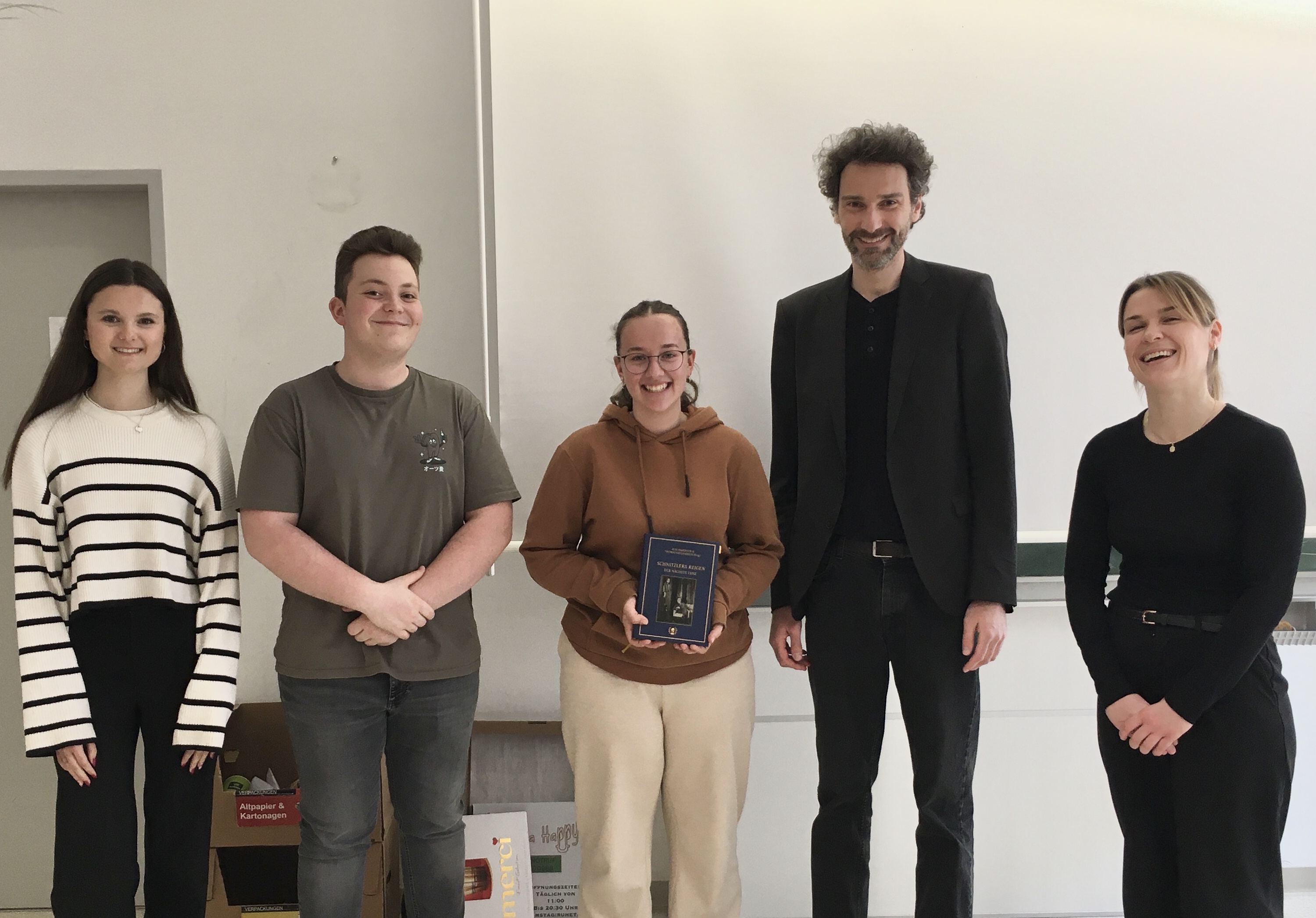 Schülerin Anna hatte während der szenischen Lesung die Regieanweisungen vorgetragen und bekam als Erste das Buch „Schnitzlers ‚Reigen‘ – Der nächste Tanz“, das nach jeder Lektüre weitergegeben werden soll. Projekt »Sternlesen«, Gymnasium Schärding, am 10.04.2025. Foto: Schülerin Hannah. Abdruck/Veröffentlichung honorarfrei bei Namensnennung.