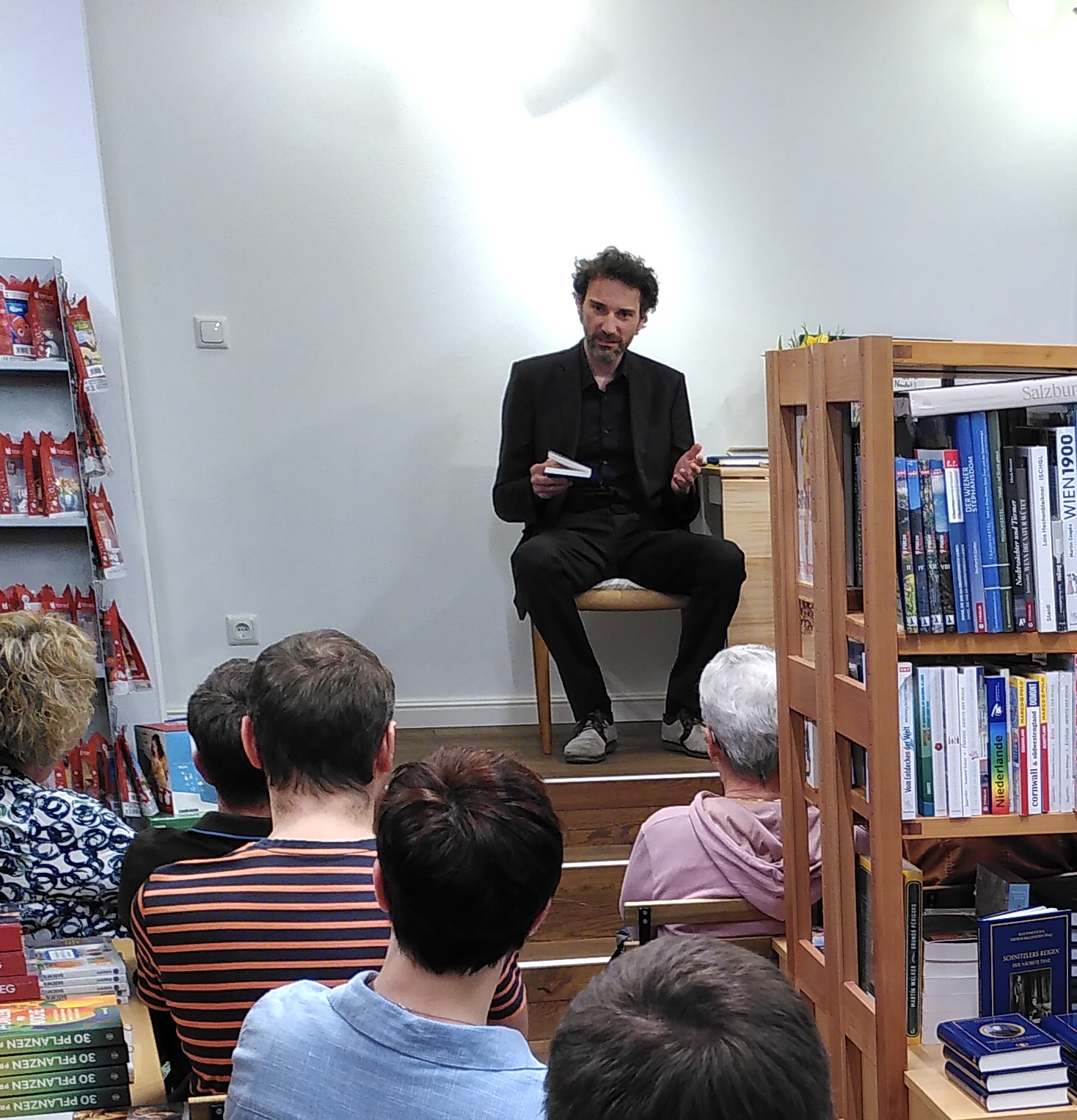 Stefan Reiser erzählt dem Publikum die Entstehungsgeschichte der Anthologie „Erzählen nach Kafka. Verwandlungen, Prozesse, Gesetze“ und berichtet von den bisherigen Stationen der Lese-Tournee. Projekt »Sternlesen«, Buchhandlung Schachinger, Schärding, am 11.04.2025. Foto: Ulrike Schachinger. Abdruck/Veröffentlichung honorarfrei bei Namensnennung.